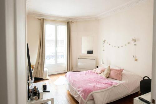 a bedroom with a pink bed and a window at Proche métro Nid Parisien - 11e in Paris