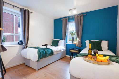 a bedroom with two beds and a table with a bottle of wine at Stylish Central Apartment with Free Parking, Fast WiFI and Smart TV by Yoko Property in Coventry
