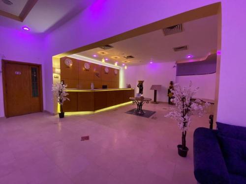Regency Lodge Hotel في شرم الشيخ: غرفة أرجوانية مع غرفة انتظار مع أضواء أرجوانية