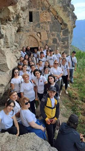 a group of people posing in front of a rock wall at Tsatʼer Guest House in Tsatʼer