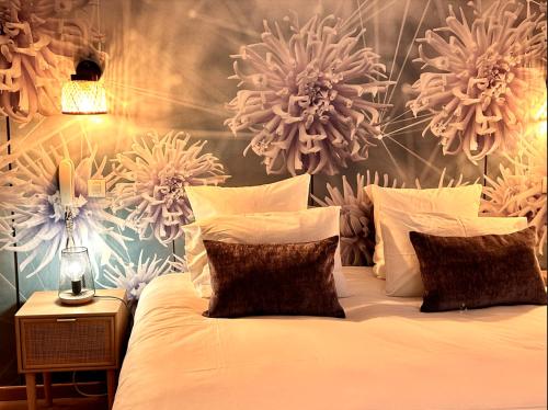 - une chambre avec un lit orné de fleurs sur le mur dans l'établissement Hôtel du Parc, à Draguignan