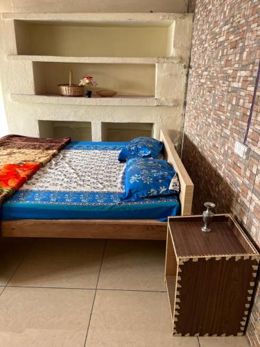 a bed with blue sheets on it in a room at Badriniwas homestays in Almora