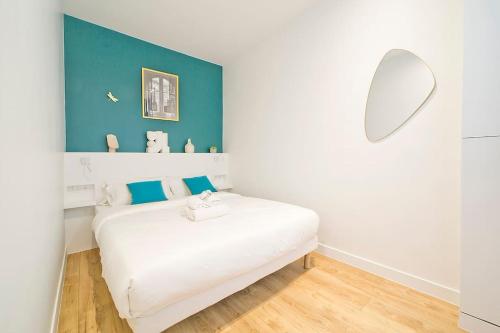 ein weißes Bett in einem Zimmer mit blauer Wand in der Unterkunft Exceptionnel à Montmartre in Paris