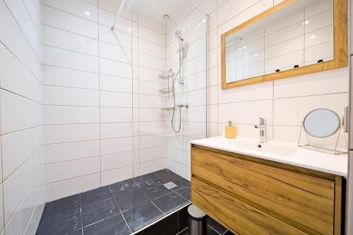 une salle de bain blanche avec un lavabo et un miroir dans l'établissement Exceptionnel à Montmartre, à Paris