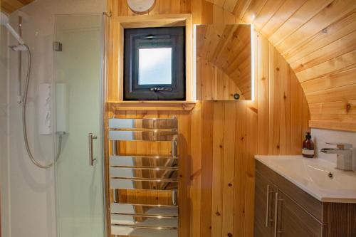 a bathroom with a sink and a tv on a wooden wall at Heisgeir in Sollas