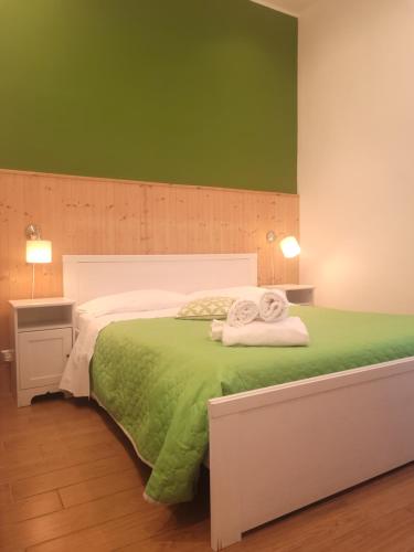 Un dormitorio verde con una cama con toallas. en XX Miglia rooms & apartments en Catania