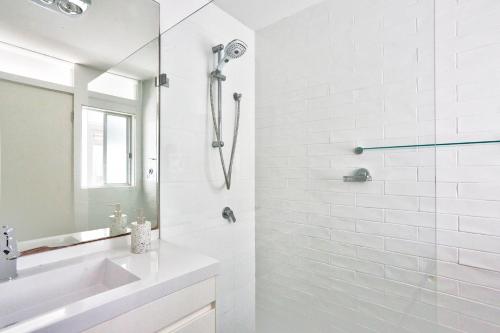 a white bathroom with a shower and a sink at Spacious 3 Bedroom House City Centre Millers Point 2 E-Bikes Included in Sydney