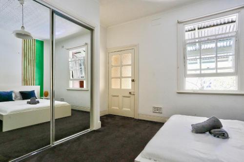 a bedroom with two beds and a mirror at Spacious 3 Bedroom House City Centre Millers Point 2 E-Bikes Included in Sydney