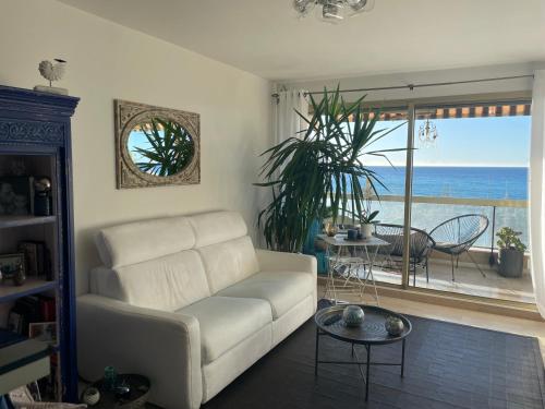 uma sala de estar com um sofá branco e vista para o oceano em Vue imprenable em Le Bouscat