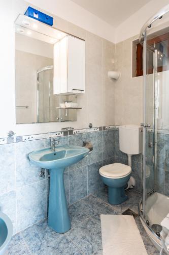 a bathroom with a blue sink and a toilet at Villa Amigo in Podstrana