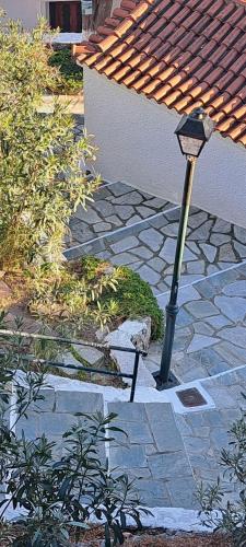 a street light sitting on a stone patio at Final step in Skiathos Town