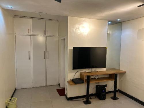 a room with a desk with a tv and a deskicterictericter at Cozy haven apartment in Lagos