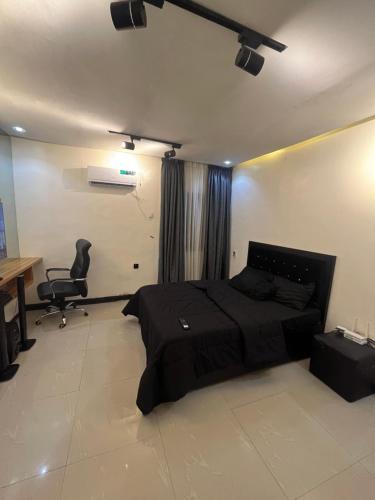 a bedroom with a bed and a desk and a chair at Cozy haven apartment in Lagos