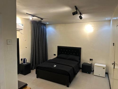 a bedroom with a black bed and some speakers at Cozy haven apartment in Lagos