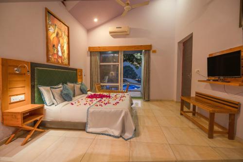 Tota ĀmにあるLaTigre Resortのベッドルーム1室(花の飾られたベッド1台付)