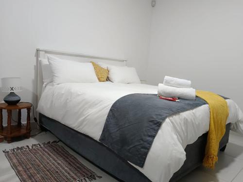 1 dormitorio con 1 cama grande con sábanas y almohadas blancas en Guest Suite 2 at Rustic Dune, en Jeffreys Bay