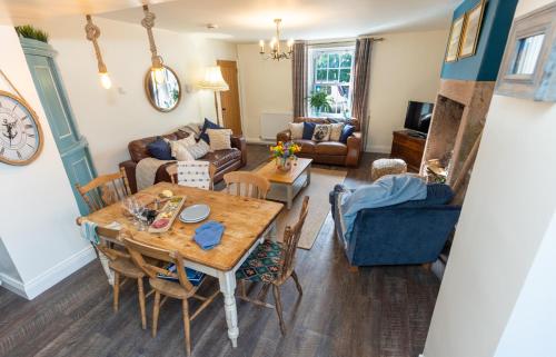 a living room with a table and a couch at Rose Cottage by Coast & Country Stays in Beadnell