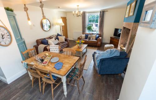 a living room with a table and a couch at Rose Cottage in Beadnell
