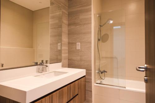een badkamer met een witte wastafel en een douche bij Luxury feel in Ras al Khaimah