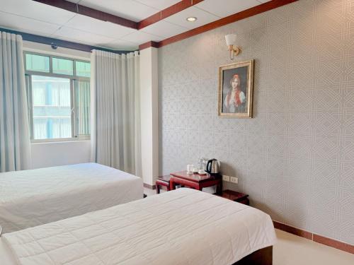 a hotel room with two beds and a window at Phúc Đạt Hotel in Vung Tau