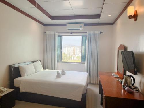 a hotel room with a bed and a window at Phúc Đạt Hotel in Vung Tau