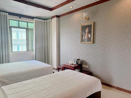 a hotel room with two beds and a window at Phúc Đạt Hotel in Vung Tau