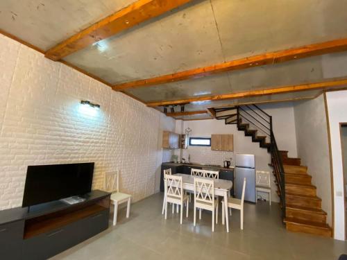 - un salon avec une table et des chaises ainsi qu'un escalier dans l'établissement cottage 3-029, à Bakuriani