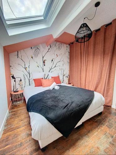 une chambre avec un grand lit avec des oreillers orange dans l'établissement La Casa Polo, à Bourgoin-Jallieu