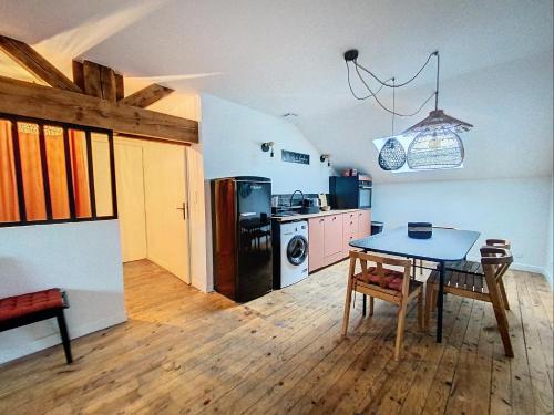 uma cozinha com uma mesa, um fogão e um frigorífico em La Casa Polo em Bourgoin