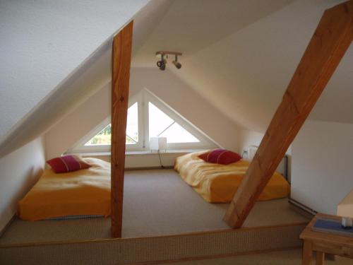 um quarto no sótão com 2 camas e uma janela em Haus Carmen auf Usedom Nr.6 em Ziemitz