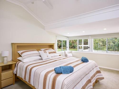 a bedroom with a large bed with two towels on it at Moonya Avocado Farm Cottage - with early check-in in Mount Tamborine