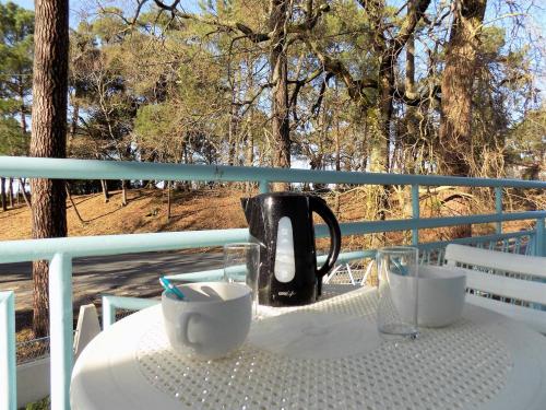une bouilloire et des tasses sur une table sur un balcon dans l'établissement Ronce-les-Bains - APPARTEMENT 1er ETAGE droit - 90m de la PLAGE, à Ronce-les-Bains
