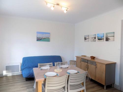 une salle à manger avec une table et un canapé bleu dans l'établissement Ronce-les-Bains - APPARTEMENT 1er ETAGE droit - 90m de la PLAGE, à Ronce-les-Bains