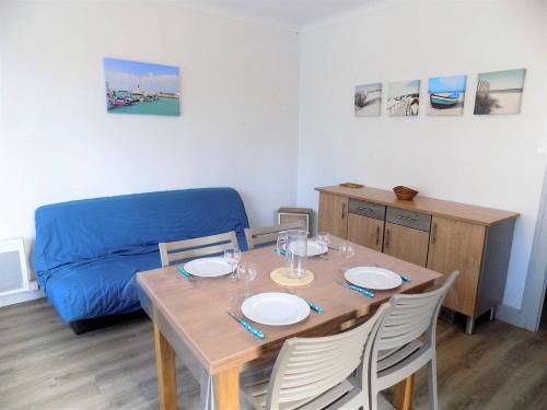 une table à manger avec des chaises et un canapé bleu dans l'établissement Ronce-les-Bains - APPARTEMENT 1er ETAGE droit - 90m de la PLAGE, à Ronce-les-Bains