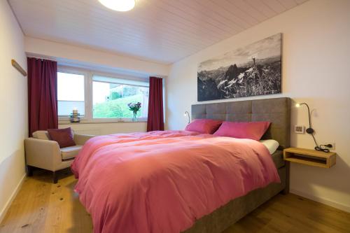a bedroom with a pink bed and a window at Berglust in Obermaiselstein