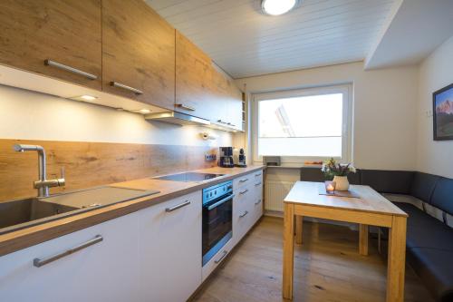 a kitchen with wooden cabinets and a sink and a table at Berglust in Obermaiselstein