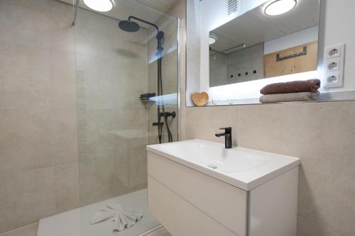 a white bathroom with a sink and a shower at Berglust in Obermaiselstein