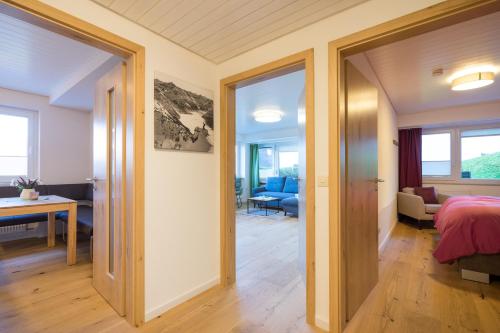 a bedroom with a door open to a living room at Berglust in Obermaiselstein