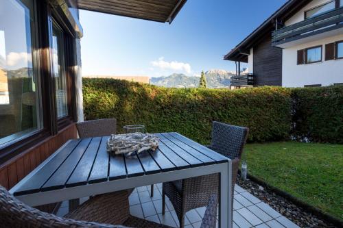 a table and chairs on a patio with a view at Berglust in Obermaiselstein