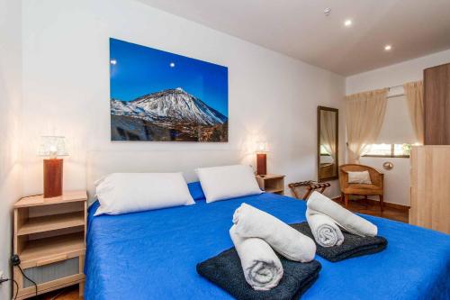 a bedroom with a blue bed with white pillows at Villa Isabel Sol in Adeje