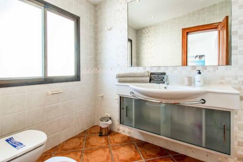 a bathroom with a sink and a toilet and a mirror at Villa Isabel Sol in Adeje