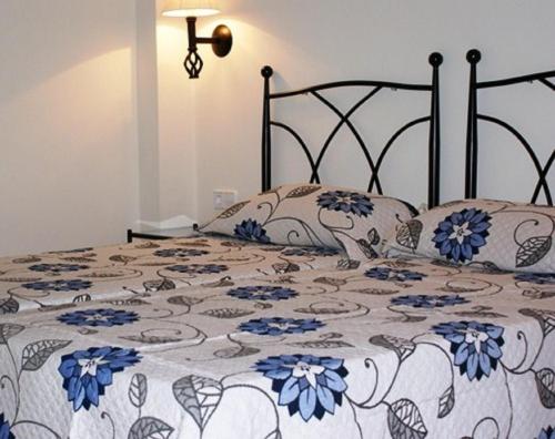 een slaapkamer met een bed met blauwe bloemen erop bij Apartamento Buganvillea in Alaior