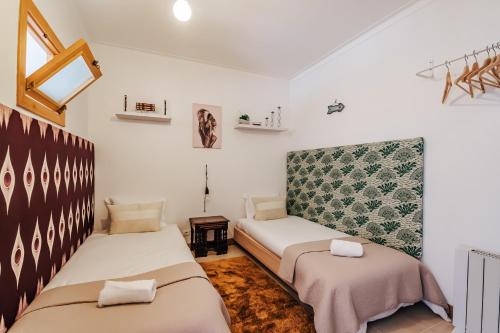 Dos camas en una habitación con paredes blancas. en Beach Front Apartment, en Ferrel