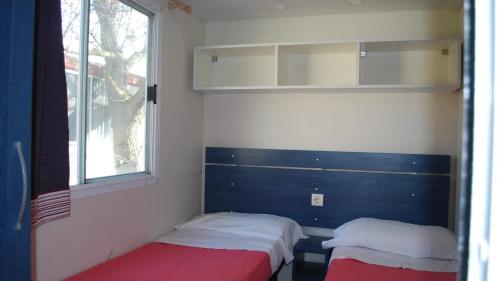リド・ディ・オスティアにあるCamping Internazionale Di Castelfusanoのベッド2台と窓が備わる客室です。