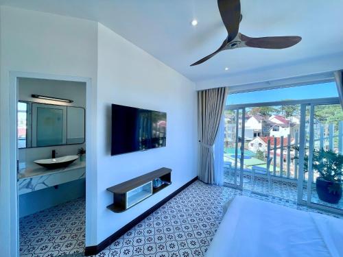 um quarto com uma cama, uma televisão e uma varanda em LE'S DALAT SKY Hotel Da Lat em Da Lat