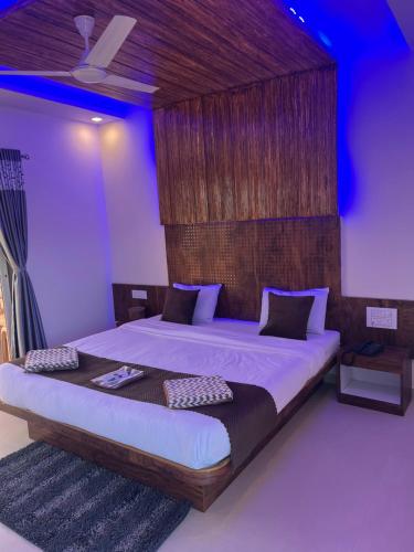 a bedroom with a large bed with a wooden headboard at Hotel Mahabaleshwar Mount View in Mahabaleshwar