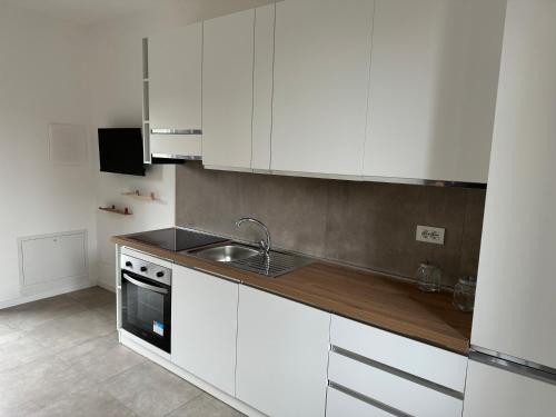 una cocina con armarios blancos y fregadero en Ambra House en Trezzano sul Naviglio