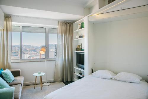 リスボンにあるApartamento acolhedor com vista Castelo de São Jorge - TTL308のベッドルーム(白いベッド1台、窓付)