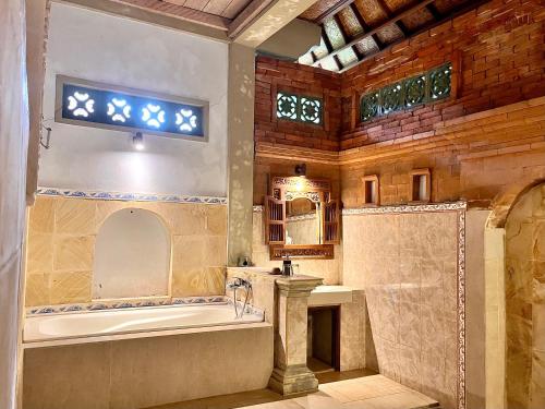 een grote badkamer met een bad en een wastafel bij Bali Moon Guest House in Ubud