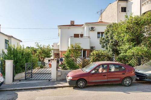 a small red car parked in front of a building at Happy Home - Rental Residence in Split